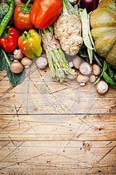 Food background with vegan cooking ingredients. Organic vegetables, pumpkin, mushrooms, asparagus, paprika, celery on old wooden