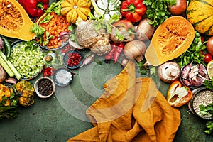 Food background. Vegetables, mushrooms, roots, spices - ingredients for vegan, cooking. Orange kitchen towel. Healthy eating, diet