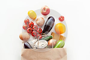 Food bag with grocery and vegetables on white