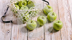 Food banner. Organic green apples and cotton string mesh bag on a wooden table