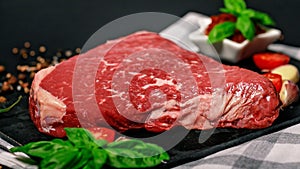 Food banner raw beef steak. Pasture raised meat with spices and herbs on a dark background