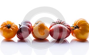 Food banner. Tomatoes of different colors and shapes on a white glossy background. Horizontal shot