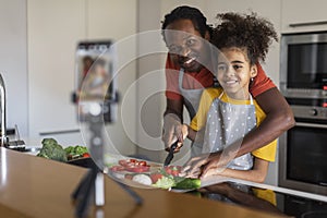 Food Blog. Black Father And Daughter Cooking At Camera In Kitchen