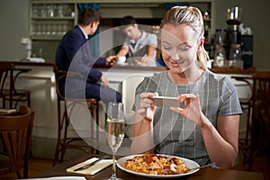 Food Blogger Taking Picture Of Restaurant Meal On Mobile Phone