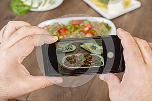 Food blogger using smartphone taking photo