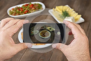 Food blogger using smartphone taking photo