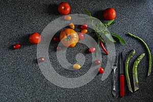 Food border with green asparagus, red and orange tomatoes and red chilli pepper with leaves.