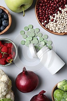 Food and bottle of prebiotic pills on grey background, flat lay