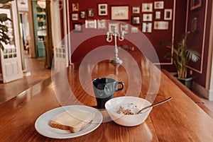 Food for breakfast at historical home. Dinning table with granola, yogurt, toast and hot coffee