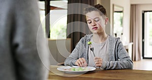 Food, Brussels sprouts and child with dislike on face sitting at table eating gross disgusting veggies. Vegetables
