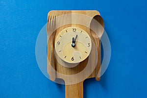 Food clock spoon and fork, Healthy food lunch concept on blue background
