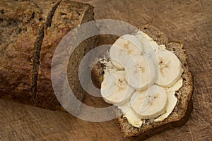 Food : Close up of a sliced, homemade banana loaf cake on a wooden board. 2