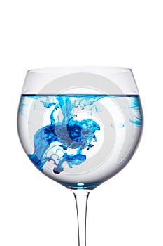 Food coloring diffuse in water inside wine glass area for slogan or advertising text message, white background.