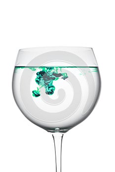 Food coloring diffuse in water inside wine glass area for slogan or advertising text message, on white background