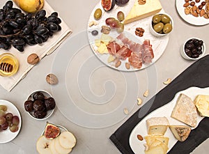 Food composition cheese platewith cheese, dry meats, various fruits and nuts. Overhead of set of pieces moldy