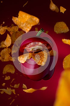 Food concept art of a flying pepper with chips. Levitating pepper with tasty junk food.