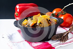 Food concept Homemade French organic Ratatouille in white bake ceramic bowl on blask slate stone board