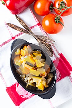 Food concept Homemade French organic Ratatouille in white bake ceramic bowl on blask slate stone board