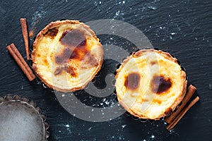 Food concept Homemade organic egg  Portuguese Custard Tarts PASTEIS DE NATA on black slate stone plate