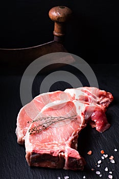 Food concept Organic Fresh pork chop on black slate stone board with vintage chopping knife with copy space