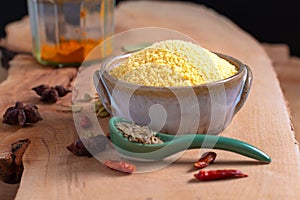 Food concept raw Couscous in brown ceramic bolw and spices on wooden board background