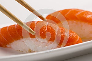 Macro Photography of Sushi rolls japanese food isolated on white background with chopsticks. California Sushi roll with tuna, vege