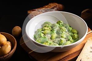 Food concept Spot focus Homemade creamy pesto gnocchi on black background with copy space