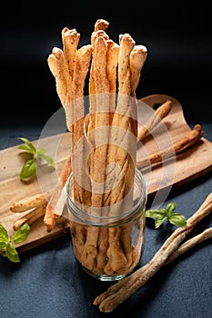 Food concept Spot focus Homemade Grissini on wooden board and black slate stone background with copy space