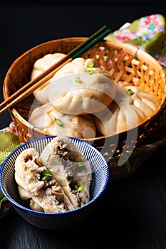 Food concept spot focus homemade organic dim sum Baozi, or bao pork Chinese Steamed Buns on black background with copy space