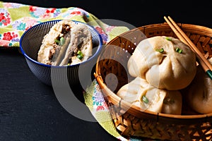 Food concept spot focus homemade organic dim sum Baozi, or bao pork Chinese Steamed Buns on black background with copy space