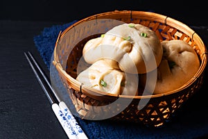 Food concept spot focus homemade organic dim sum Baozi, or bao pork Chinese Steamed Buns on black background with copy space