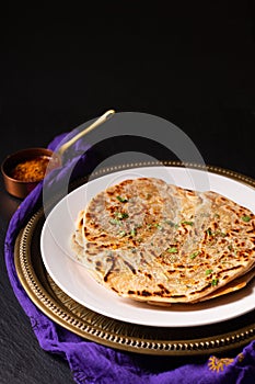 Food concept spot focus homemade Paratha, Parotta or Porotta layered flatbread  on black background with copy space