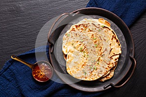 Food concept spot focus homemade Paratha, Parotta or Porotta layered flatbread  on black background with copy space