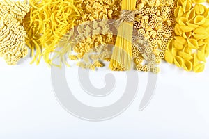 Food concept - various uncooked, raw Italian pasta on white background, top view, place for text, set