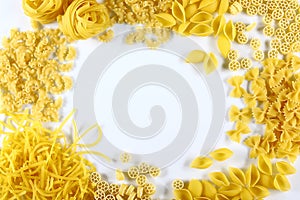 Food concept - various uncooked, raw Italian pasta on white background, top view, place for text, set
