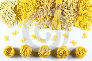Food concept - various uncooked, raw Italian pasta on white background, top view, set