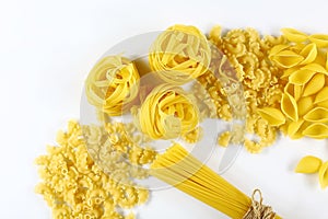 Food concept - various uncooked, raw Italian pasta on white background, top view, set