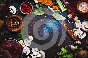 Food cooking background. Fresh organic vegetables, ingredients, spices and meat for warm autumn soup on vintage kitchen table with