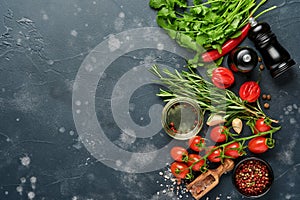 Food cooking background. Fresh rosemary, cilantro, basil, cherry tomatoes, peppers and olive oil, spices herbs and vegetables at