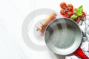 Food cooking background with Frying pan, herbs and utensil on white table.