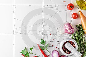 Food cooking background on white tile table. Fresh vegetables, spices, herbs and oil. Top view. Ingredients for cooking