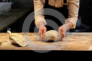 Baker making bread dough at bakery kitchen