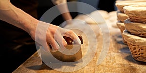 Baker portioning dough with bench cutter at bakery photo