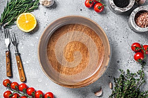 Food cooking and healthy eating background with empty rustic plate and fresh seasoning, knife, fork and vegetables