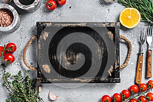 Food cooking and healthy eating background with wooden cutting board and fresh seasoning, herbs and vegetables. Gray