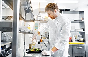 Happy male chef cooking food at restaurant kitchen