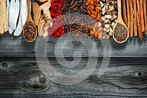 Food and cuisine ingredients. Colorful natural additives.Spices and seasonings on the wooden spoon and the gray wooden background.