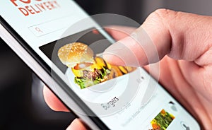 Food delivery app order with phone. Online mobile service for take away burger and pizza. Hungry man reading restaurant menu.