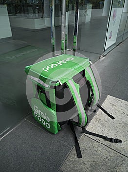 A food delivery bag is placed on the ground while delivery guy collect the food.