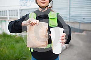 Food delivery concept. The food delivery woman has a green fridge backpack. She wants to deliver faster and get to